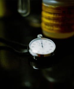 stopwatch with chain focused in portrait mode, set against a dark countertop